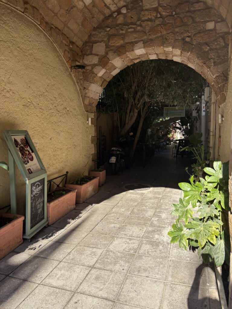 Sunlit stone archway opening onto a quiet passage