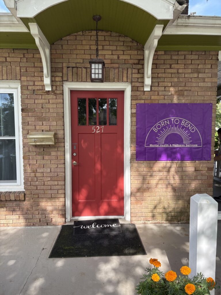 Front entrance of Born to Bend's Hendersonville office at 527 N. Justice Street, with a red door and purple Born to Bend sign